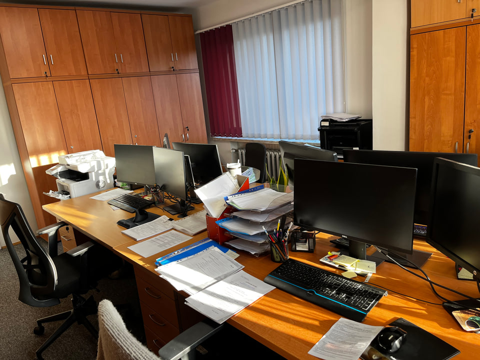 Wnętrze biura rachunkowego PROFIT z biurkami, monitorami, drewnianymi szafami i oknem z żaluzjami